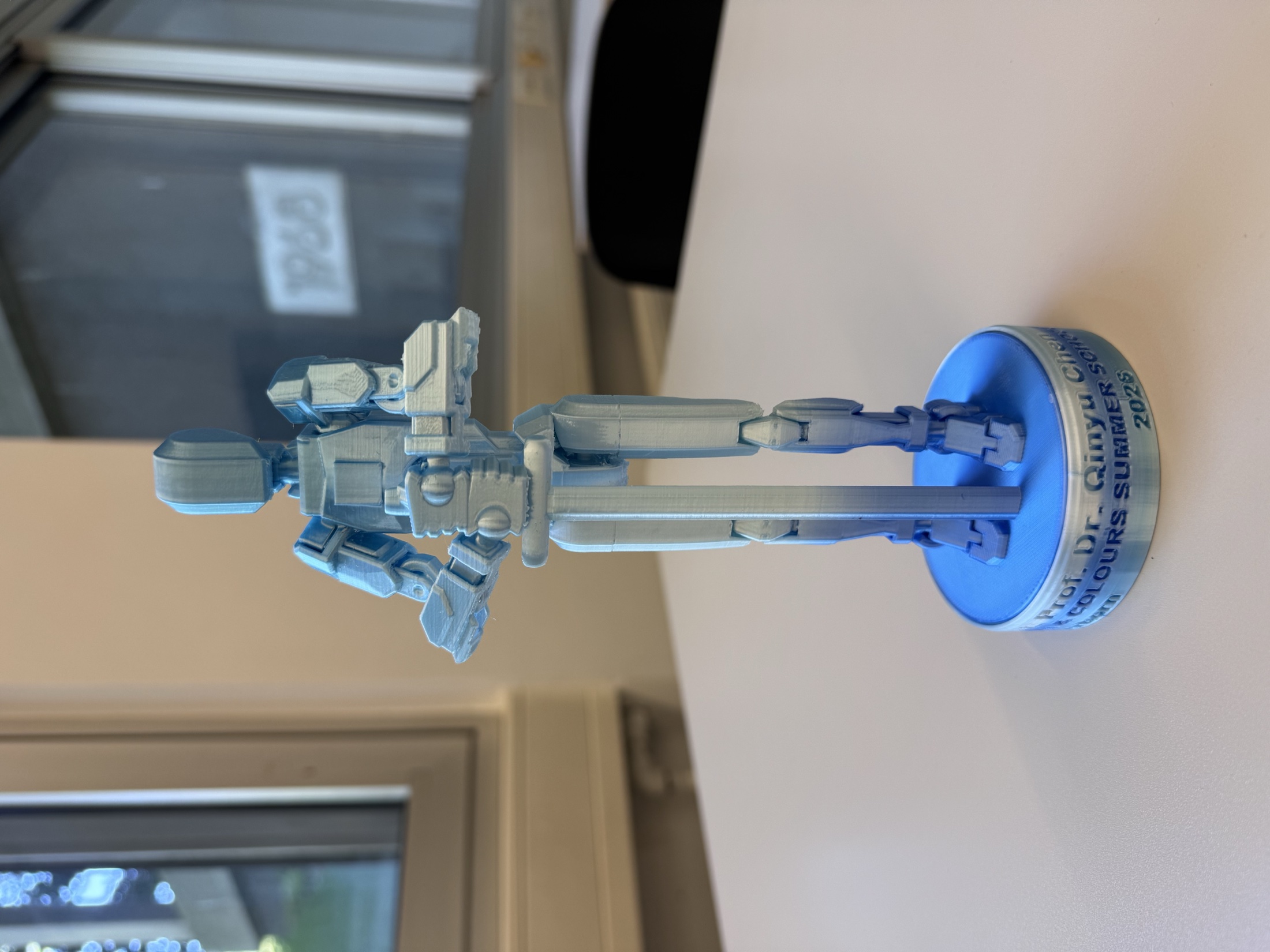 Blue 3D-printed robot sculpture presented at the summer school